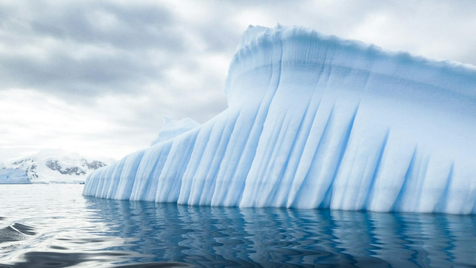 Blue iceberg reflected in polar waters