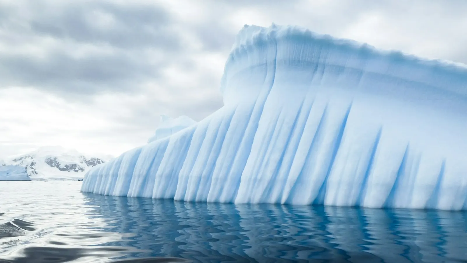 Blue iceberg reflected in polar waters
