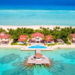 Complexe balnéaire luxueux avec des villas et des eaux turquoise.