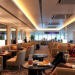 Luxury airport lounge with plush seating and gourmet snacks.