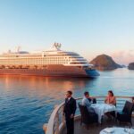 Navio de cruzeiro de luxo em águas tropicais ao pôr do sol.