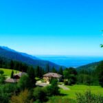 Propriedade isolada em uma paisagem verdejante com montanhas.