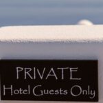 a private hotel guest only sign on a white wall