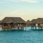 a row of huts sitting on top of a body of water