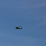 black helicopter flying in the sky during daytime