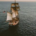 brown sailboat in beach under white sky