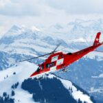 photo of flight of red and white rescue helicopter during snow daytime