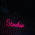 Commissioning Art on the Road: Private Studio Visits and Bespoke Pieces a neon sign that reads studio on the side of a building
