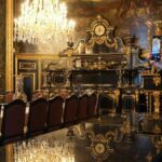 People take photos in a lavish dining room.