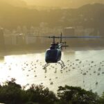 gray helicopter flying near buildings during daytime