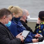man in black jacket holding white tablet computer