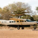 a small plane sitting on top of a dirt field