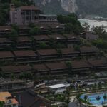Resort buildings on a steep, tree-covered hillside overlooking town.
