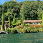 a house on the shore of a lake surrounded by trees