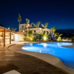 Luxury resort pool area at night with ambient lighting.