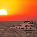 white yacht on sea during sunset