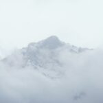 Snow-capped mountain peak emerging from clouds