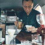 man in vehicle serving coffee