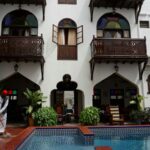 a person in a garment standing next to a pool