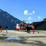 a group of people standing next to a helicopter