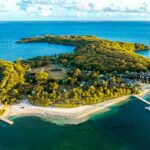 Maldives vs Seychelles for Buyout Privacy and Tidal Lagoons Lush green island resort surrounded by clear blue ocean water.