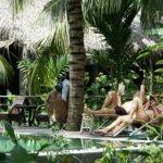 people sitting on chairs by a pool