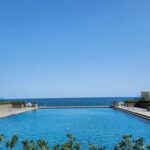 a large swimming pool with a view of the ocean