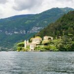 a large white house sitting on top of a lush green hillside