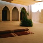 a courtyard with a planter and a rug