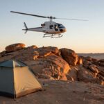 Helicopter near desert ridge at sunrise, cooling tent in foreground.