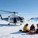 Helicopter landing on arctic glacier for a picnic.