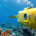 Submersible exploring coral reef with children.